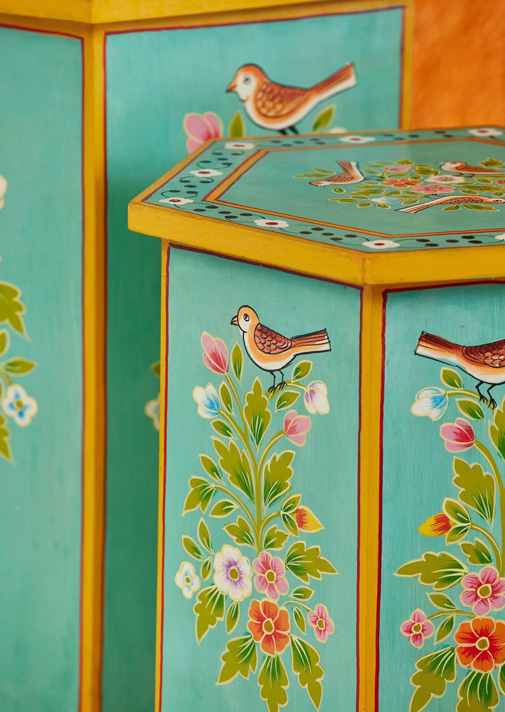 Close-up of The Chaman Tables showing hand-painted birds, flowers and turquoise panels