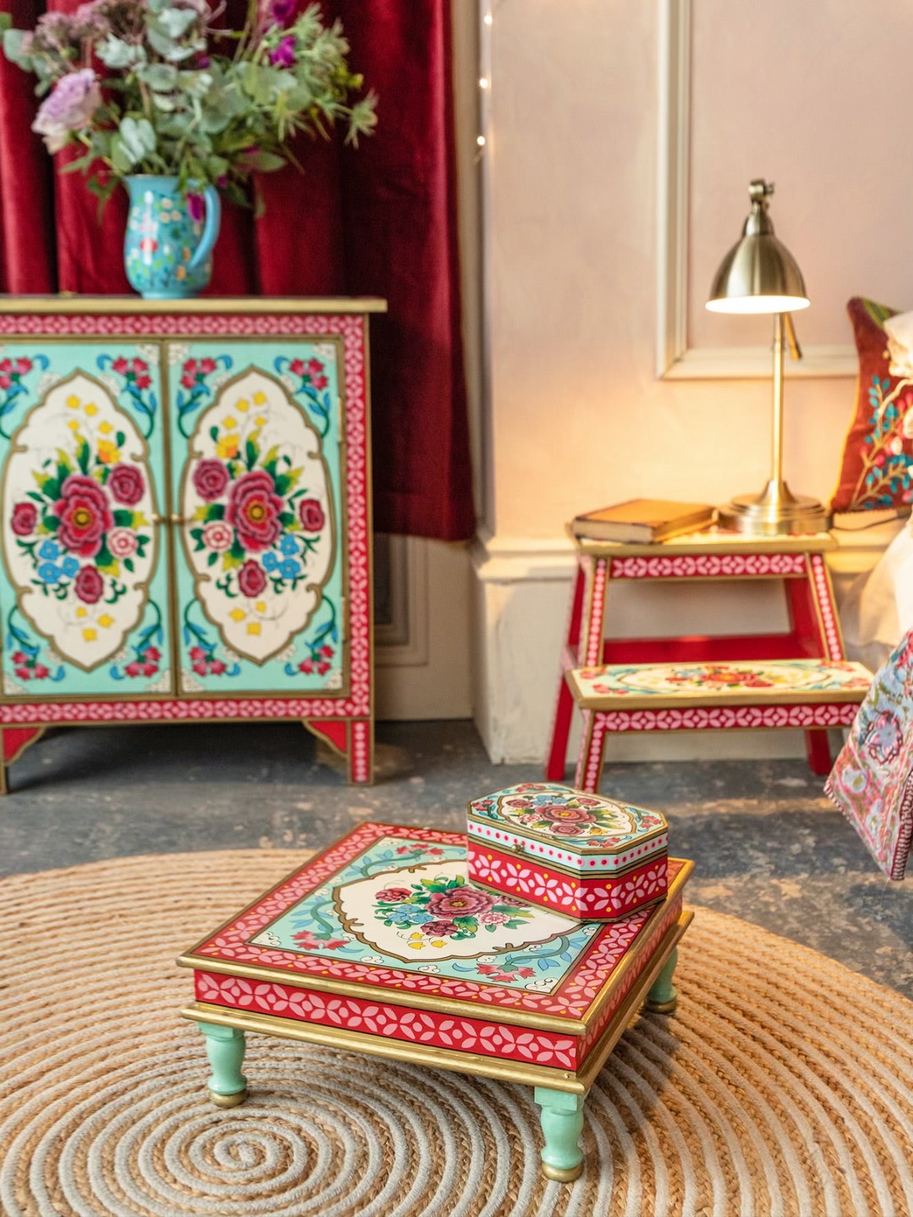 The Gulbahar hand-painted square chowki table styled in a colourful bedroom