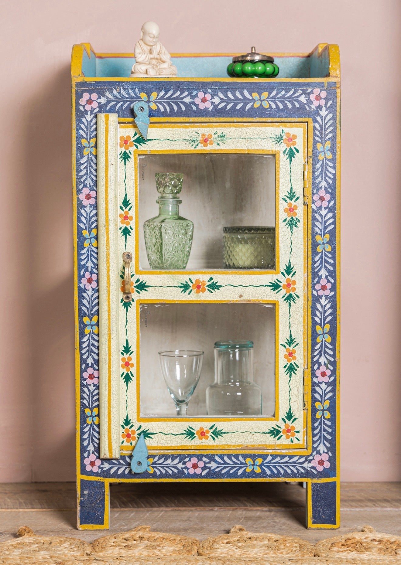 Front view of The Neelam hand-painted glass display cabinet with blue floral border and cream door