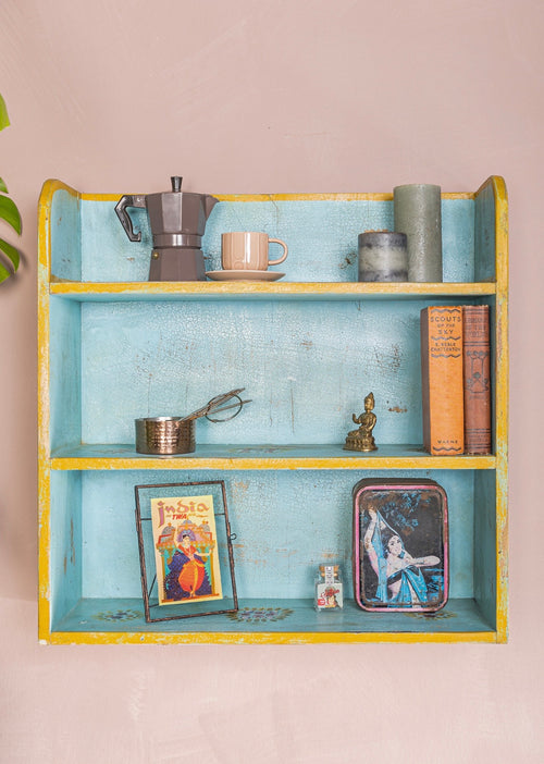 Front view of The Aabshar hand-painted turquoise wall shelf with yellow trim and distressed finish