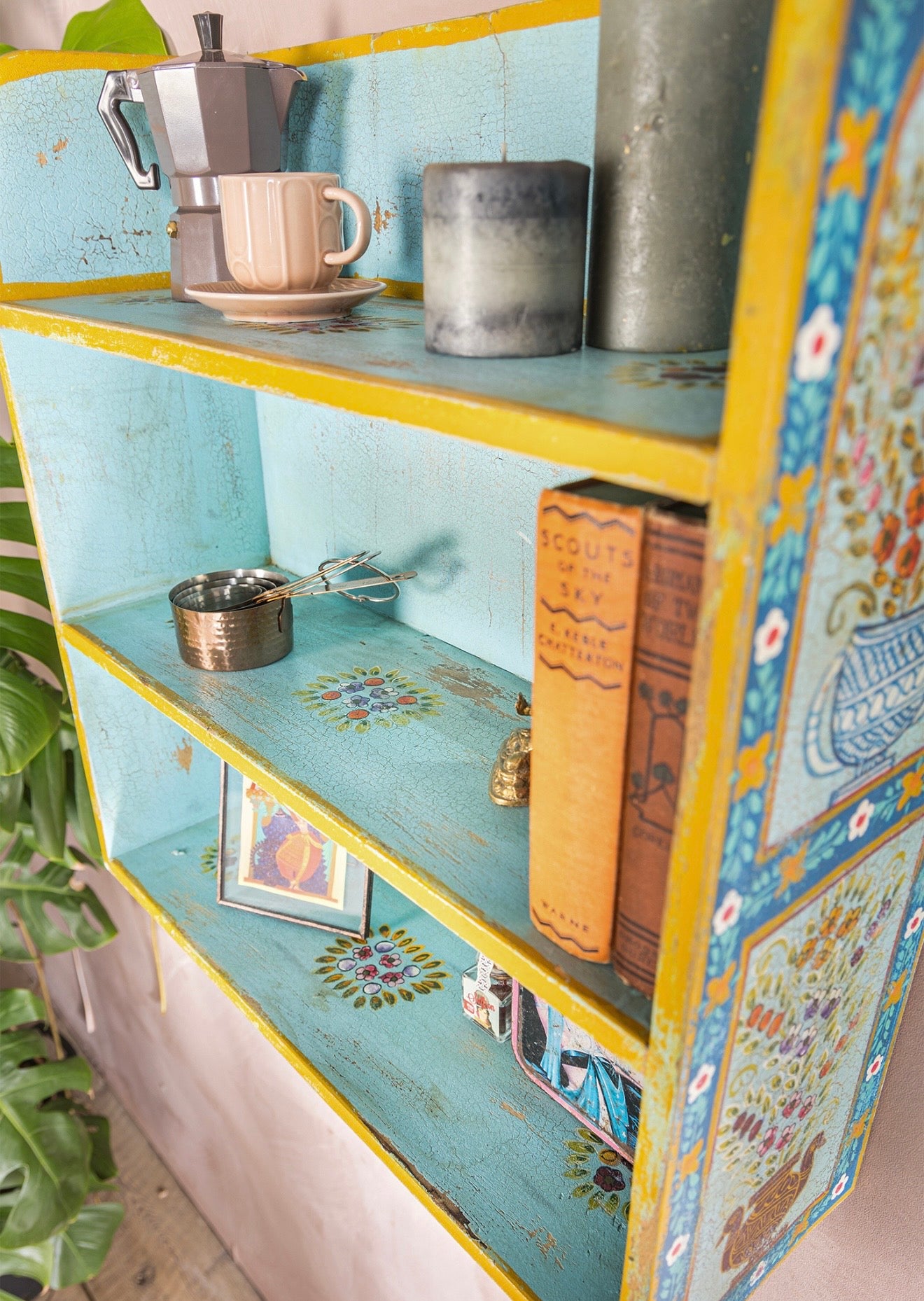 The Aabshar hand-painted wall shelf styled with books, candles and decorative objects